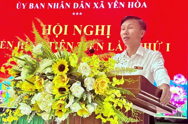 A person standing at a podium with flowers

AI-generated content may be incorrect.